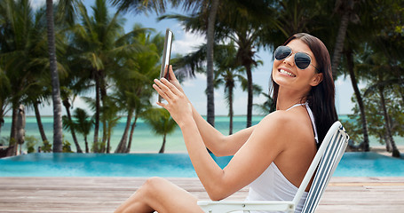 Image showing smiling woman with tablet pc sunbathing on beach