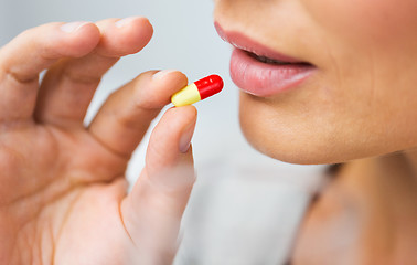 Image showing close up of woman taking medicine in pill