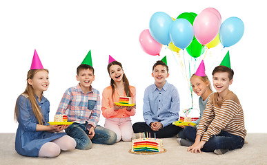 Image showing happy children in party hats with birthday cake