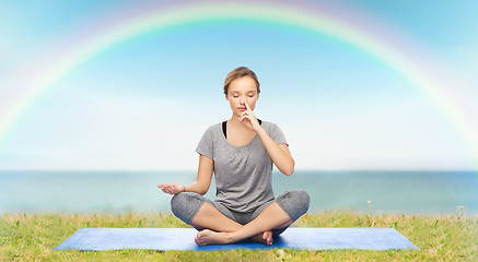 Image showing woman making yoga meditation in lotus pose on mat