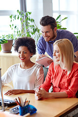 Image showing happy creative team with computer in office