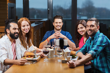 Image showing friends taking selfie by smartphone at restaurant