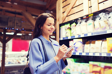 Image showing happy woman with notepad in market