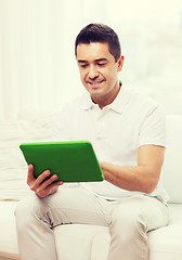 Image showing smiling man working with tablet pc at home