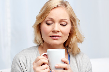 Image showing woman with cup of tea or coffee at home