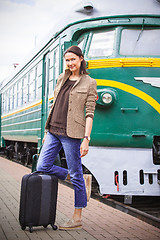 Image showing beautiful middle-aged woman with luggage on a railway platform n