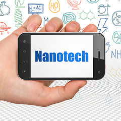 Image showing Science concept: Hand Holding Smartphone with Nanotech on display