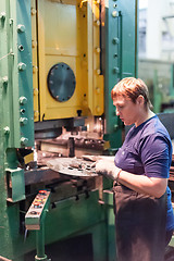 Image showing Senior woman stamps details on hydraulic press