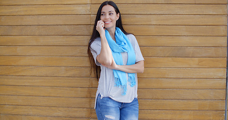 Image showing Woman on phone and leaning against wall