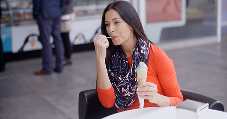Image showing Woman eating an ice cream in a parlor or cafe