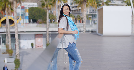 Image showing Smiling woman looking back over railing