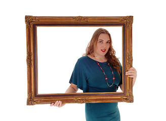 Image showing Woman holding and looking trough picture frame.