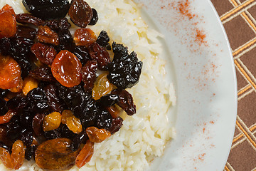 Image showing Vegetarian sweet rice with dried apricots and raisins close-up on the table. 