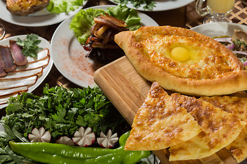 Image showing table with normal food, steaks and potatoes. 