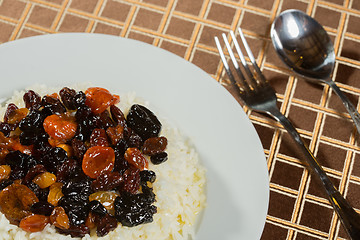 Image showing Vegetarian sweet rice with dried apricots and raisins close-up on the table. 