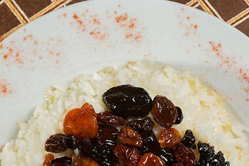 Image showing Vegetarian sweet rice with dried apricots and raisins close-up on the table. 