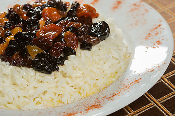 Image showing Vegetarian sweet rice with dried apricots and raisins close-up on the table. 