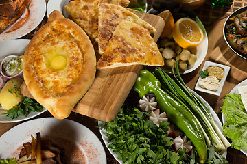 Image showing table with normal food, steaks and potatoes. 