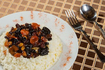 Image showing Vegetarian sweet rice with dried apricots and raisins close-up on the table. 