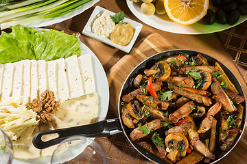 Image showing table with normal food, steaks and potatoes. 