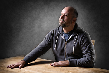 Image showing Man sitting on table