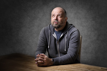 Image showing Man sitting on table