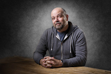 Image showing Man sitting on table