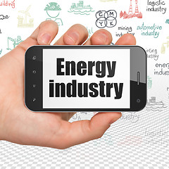 Image showing Manufacuring concept: Hand Holding Smartphone with Energy Industry on display