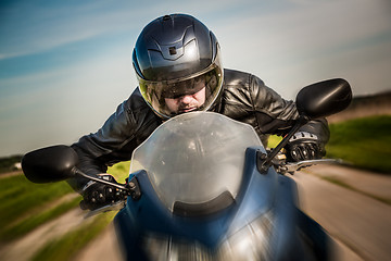 Image showing Biker racing on the road