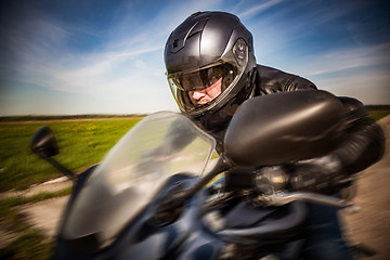 Image showing Biker racing on the road