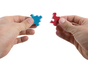 Image showing Close-up of hands trying to connect big jigsaw puzzle pieces