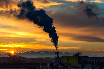 Image showing Sunrise silhouette of smoking factory