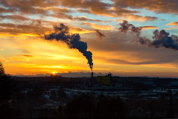 Image showing Sunrise silhouette of smoking factory