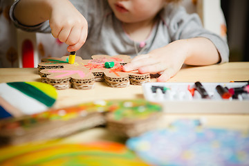 Image showing Little female baby painting with colorful paints