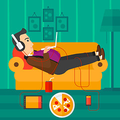 Image showing Man lying on sofa with many gadgets.