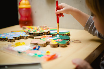 Image showing Little female baby painting with colorful paints