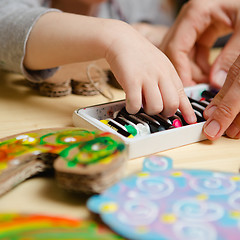 Image showing Little female baby painting with colorful paints