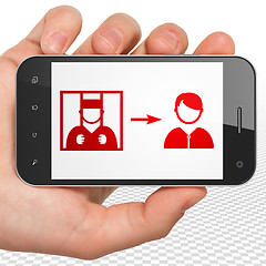 Image showing Law concept: Hand Holding Smartphone with Criminal Freed on display