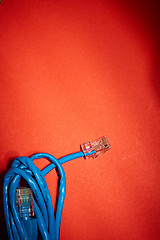 Image showing Blue network cable on red background