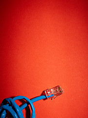 Image showing Blue network cable on red background