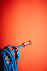 Image showing Blue network cable on red background