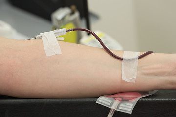 Image showing Donor in an armchair donates blood,, close-up