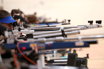 Image showing young woman aiming a pneumatic air rifle on sports competition