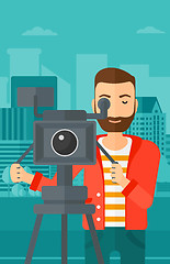 Image showing Cameraman with movie camera on a tripod.