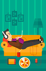 Image showing Man lying on sofa with many gadgets.