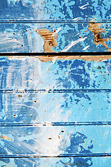 Image showing stripped  in  blue   door and rusty nail