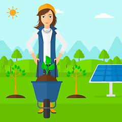 Image showing Woman with plant and wheelbarrow.