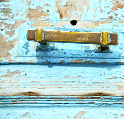 Image showing rusty metal nail dirty stripped paint in the blue wood door and 