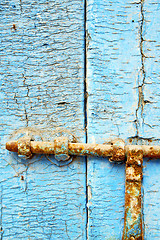 Image showing      nail dirty stripped paint in the blue wood door 