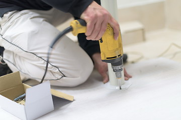 Image showing repairman working with drilling machine